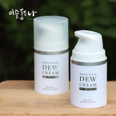 Two bottles of Dew Cream on a wooden surface with a blurred green background.