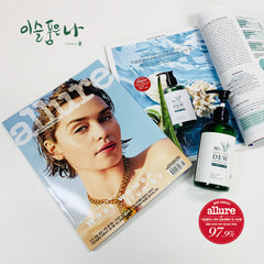 Allure Magazine with a woman's face on the cover and 90% Aloe Vera Dew skincare products on a white background