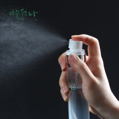 Hand holding a spray bottle with a dark background