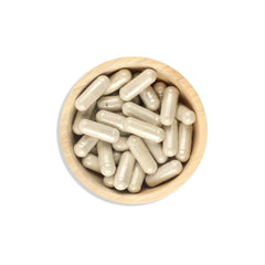Wooden bowl filled with white capsules on a white background