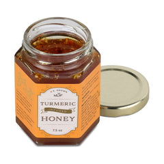 Jar of NUF turmeric infused honey with a gold lid on a white background