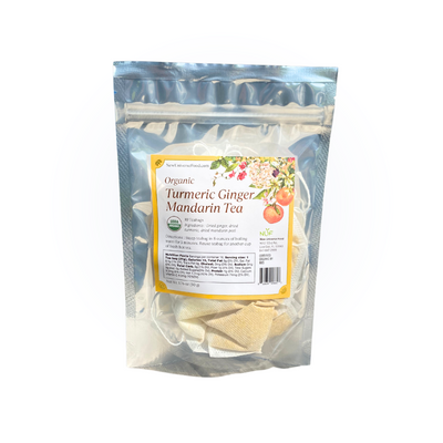 Packaged organic turmeric ginger mandarin tea on a white background