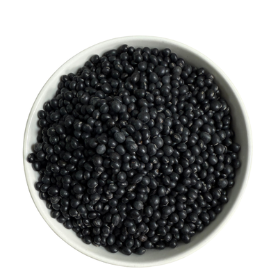 White bowl filled with black soy beans on a white background