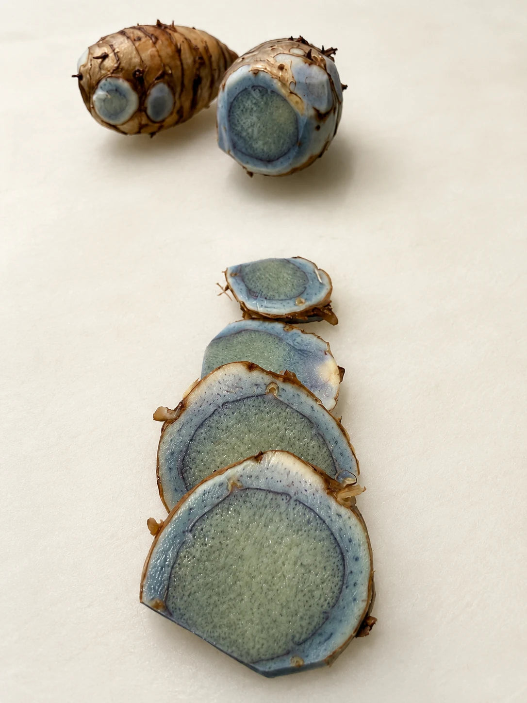 Fresh black turmeric rhizomes and slices with blue-purple interior